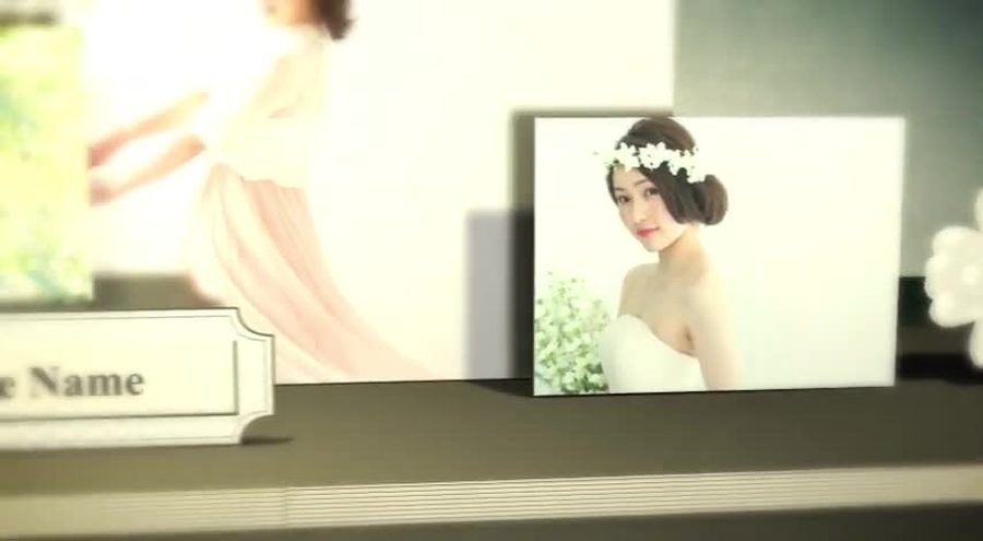 同じ飛び出す絵本風の構成でBride Nameの札が置かれ新婦の写真パネルが奥行きを変えて並ぶ。光が差し込むような演出も加わる新婦パートの本編シーン