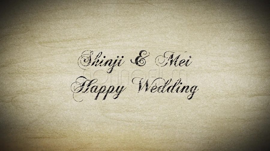 クラフト紙のような質感の背景に筆記体の文字でHappy Weddingの文字を表示するオープニングシーン